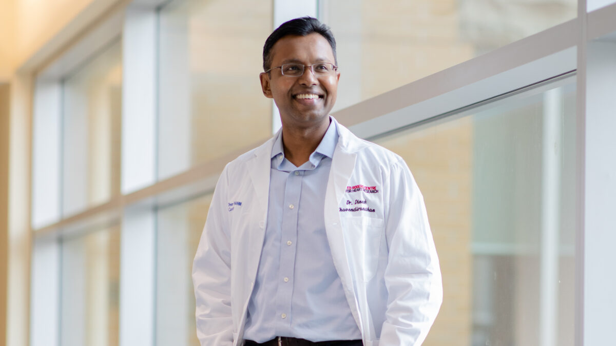 ​​Dr. Dinesh Thavendiranathan smiles as he stands in the hallway of the Peter Munk Cardiac Centre.