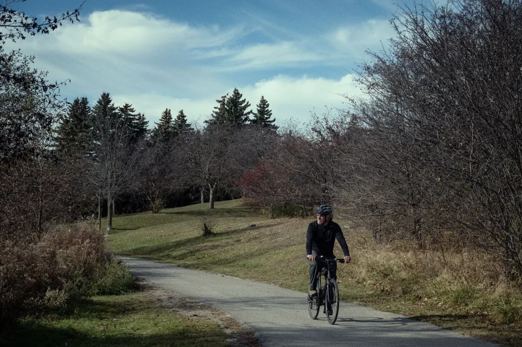 Brad Pope riding a bicycle through the park